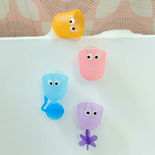 Colorful bath toys with googly eyes on a tub edge.