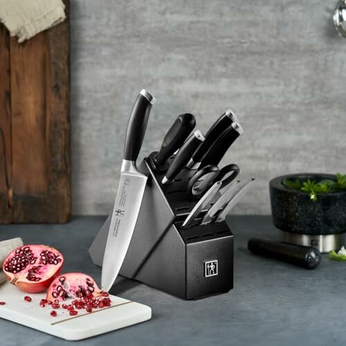 Knife set with black block on kitchen counter with pomegranate and mortar