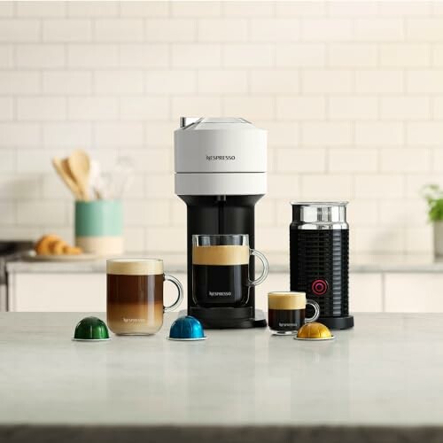 Nespresso coffee maker with cups and capsules on a kitchen counter.