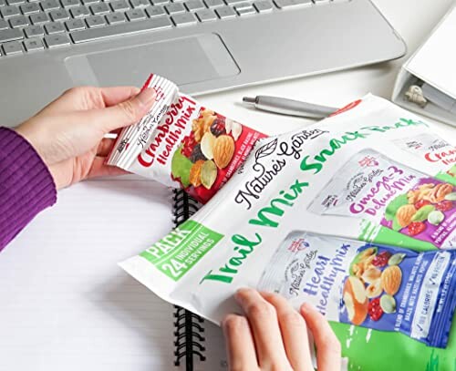 Person holding a packet of Cranberry Health Mix snacks over a notebook.